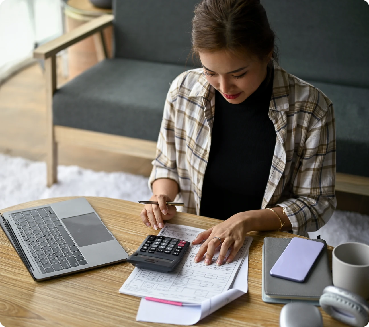 Woman budgeting at table with laptop.