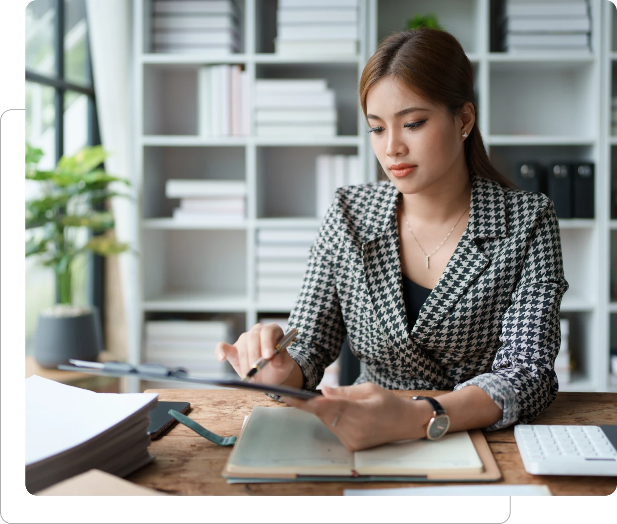 Woman working at desk with notebook.