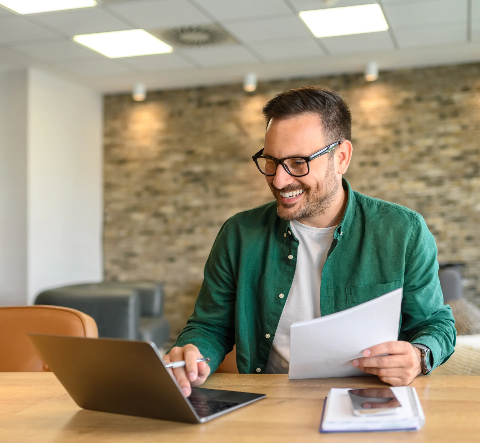 Man smiling while working on laptop.